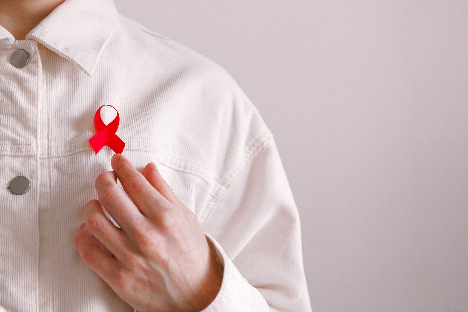 Мъж с червена панделка на ризата си в Световния ден за борба със СПИН