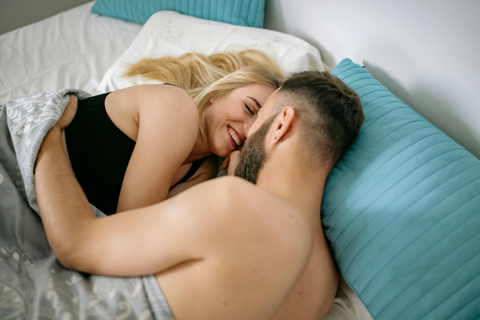 Мъж и жена се прегръщат в леглото като уелнес програма